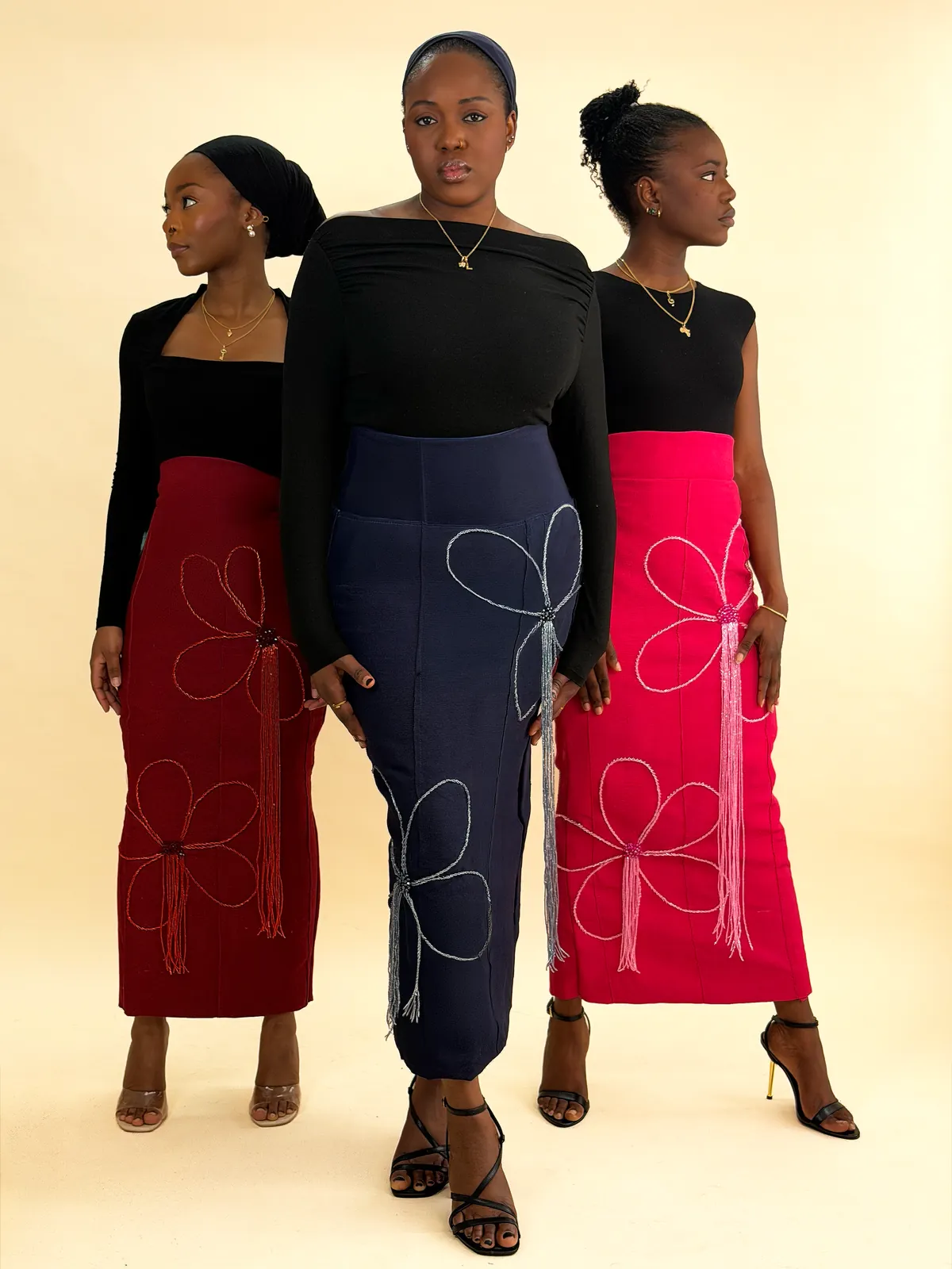 Three models in the Ododo hand-beaded skirt, in wine, navy and hot pink